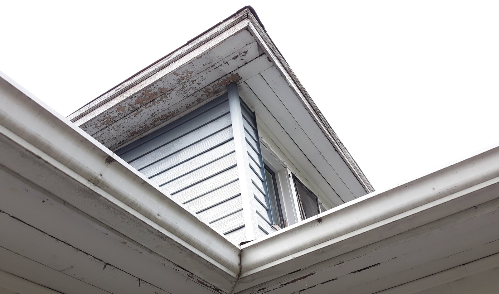 Soffit and fascia corner with paint failed back to bare wood