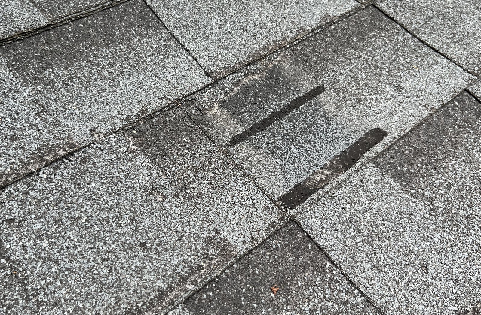 Roofing sealant smeared across shingle seams as a previous repair