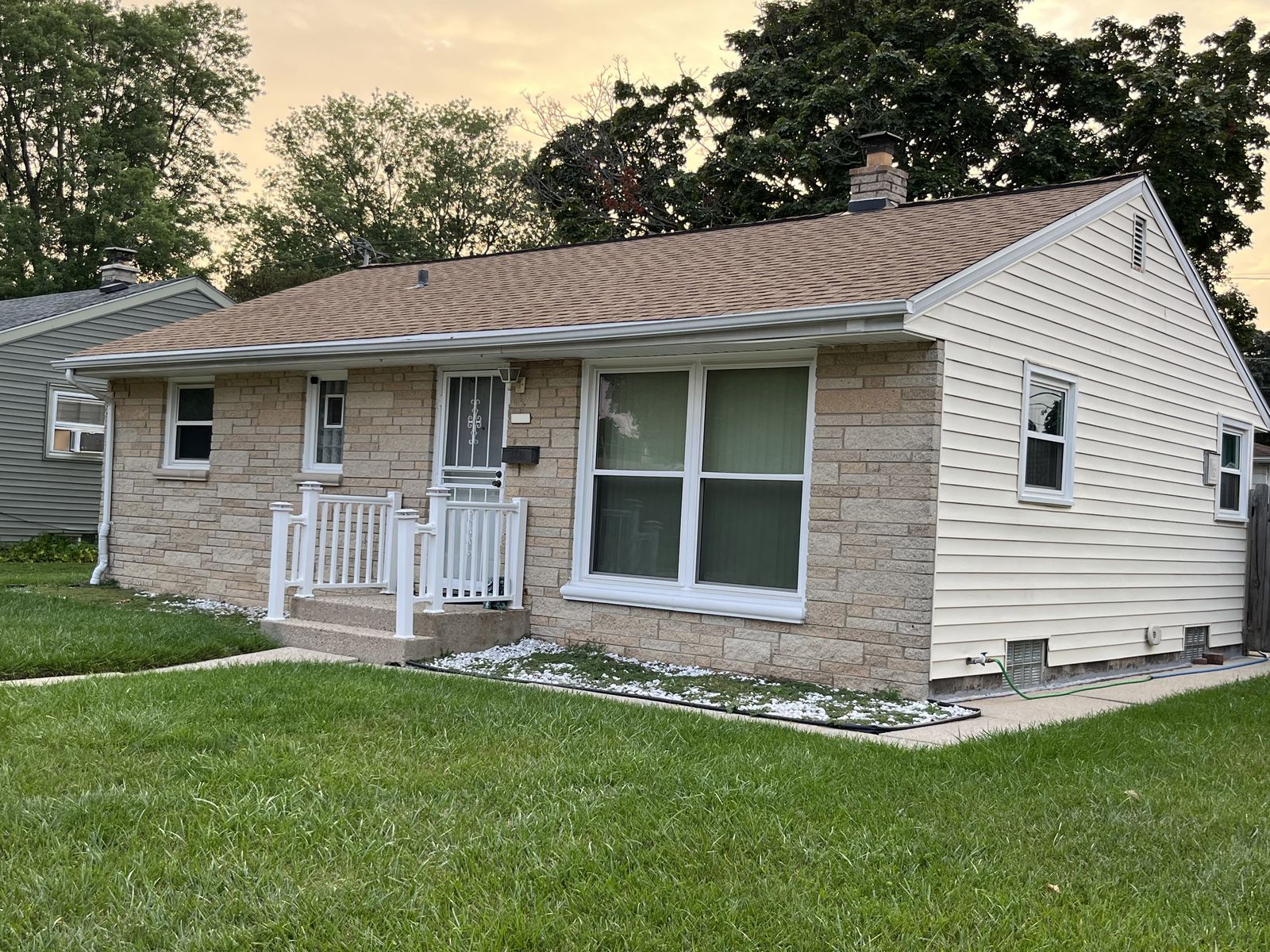 Completed asphalt roof on a cream brick Milwaukee ranch